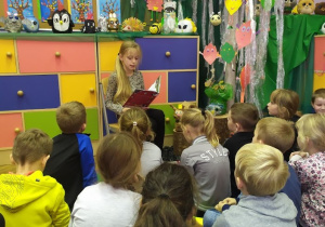 Uczennica klasy IVb i zasłuchane w czytaną przez nią opowiść dzieci z klasy pierwszej.
