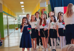 Uczennica wykonuje pieśń patriotyczną