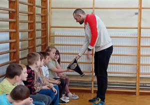 Uczniowie oglądają zwycięski pas trenera