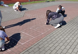 Uczennice rysują grę planszową
