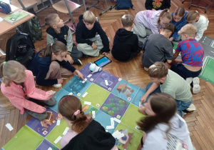 Uczniowie programują robota.