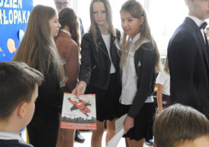 Dziewczynki z Samorządu Uczniowskiego wręczają chłopcom dyplomy.