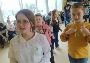 Uczniowie z żółto-niebieskimi kokardami.