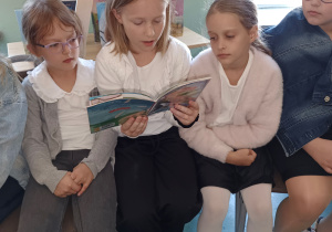 Uczennica czyta książkę klasie