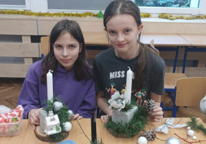 Uczennice tworzą stroiki bożonarodzeniowe.