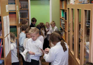 Uczniowie klas pierwszych wybierają książki w bibliotece