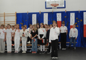 Uczennica śpiewa pieśń patriotyczną