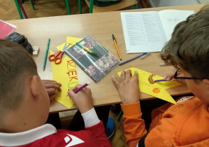Uczniowie pracują nad znakami z dobrymi słowami.